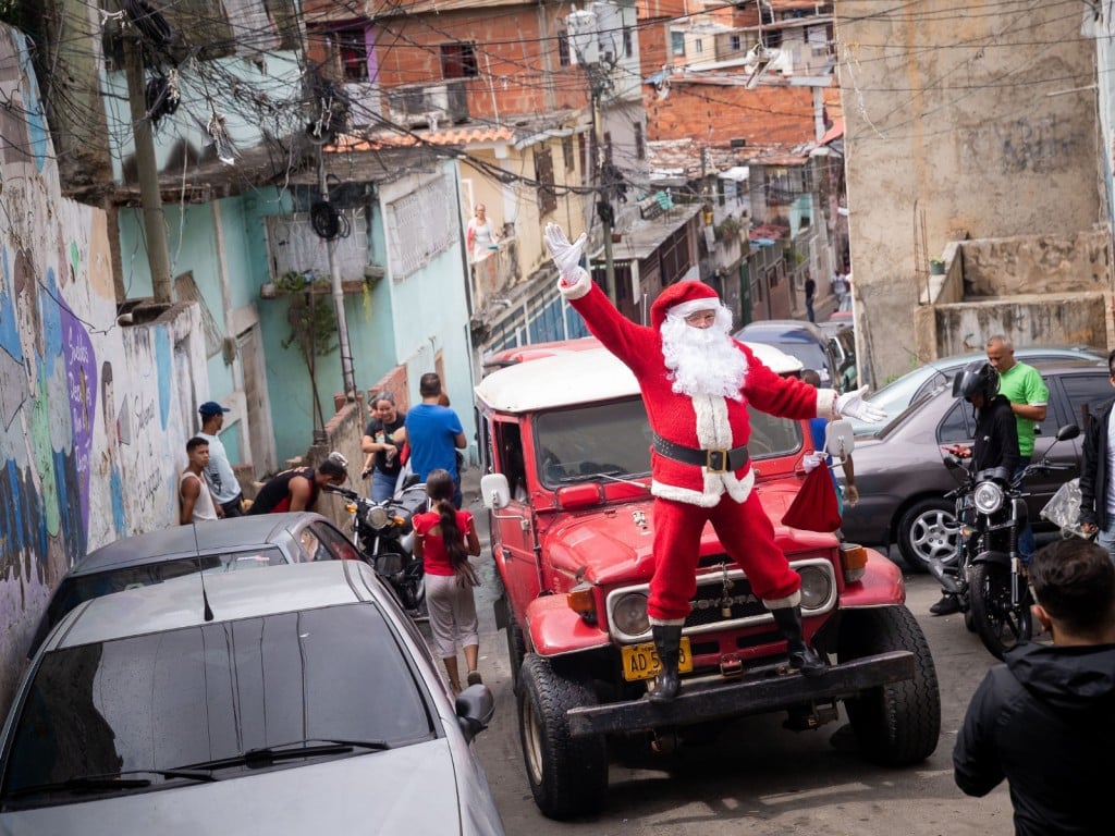 Un hombre vestido de Santa Claus carga una bolsa de regalos 