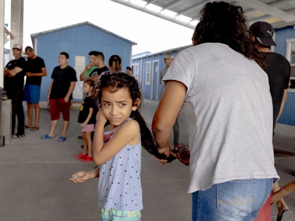 Una niña mientras le cepillan el cabello en Reynosa