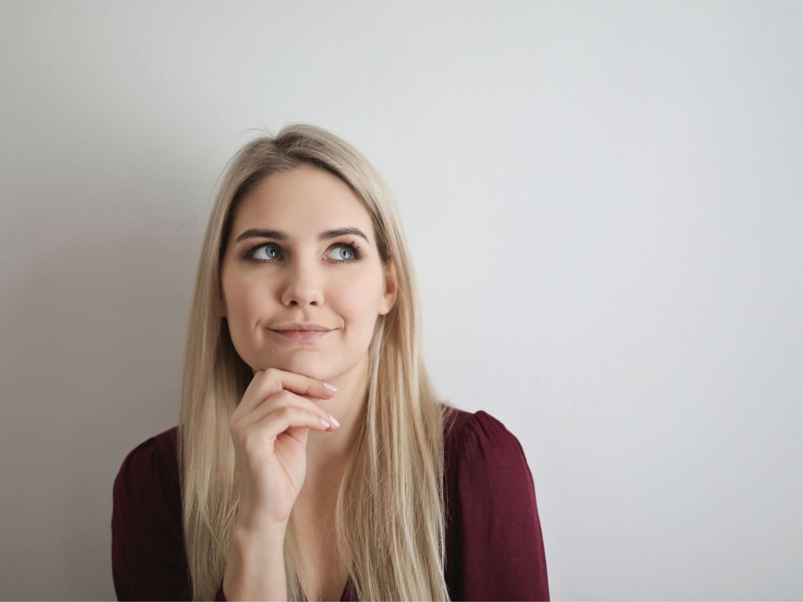 Joven pensativa sonriendo levemente.