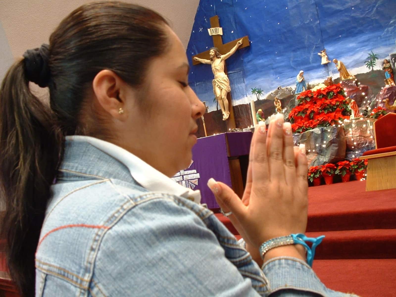 Una mujer hispana no identificada reacciona durante un servicio religioso