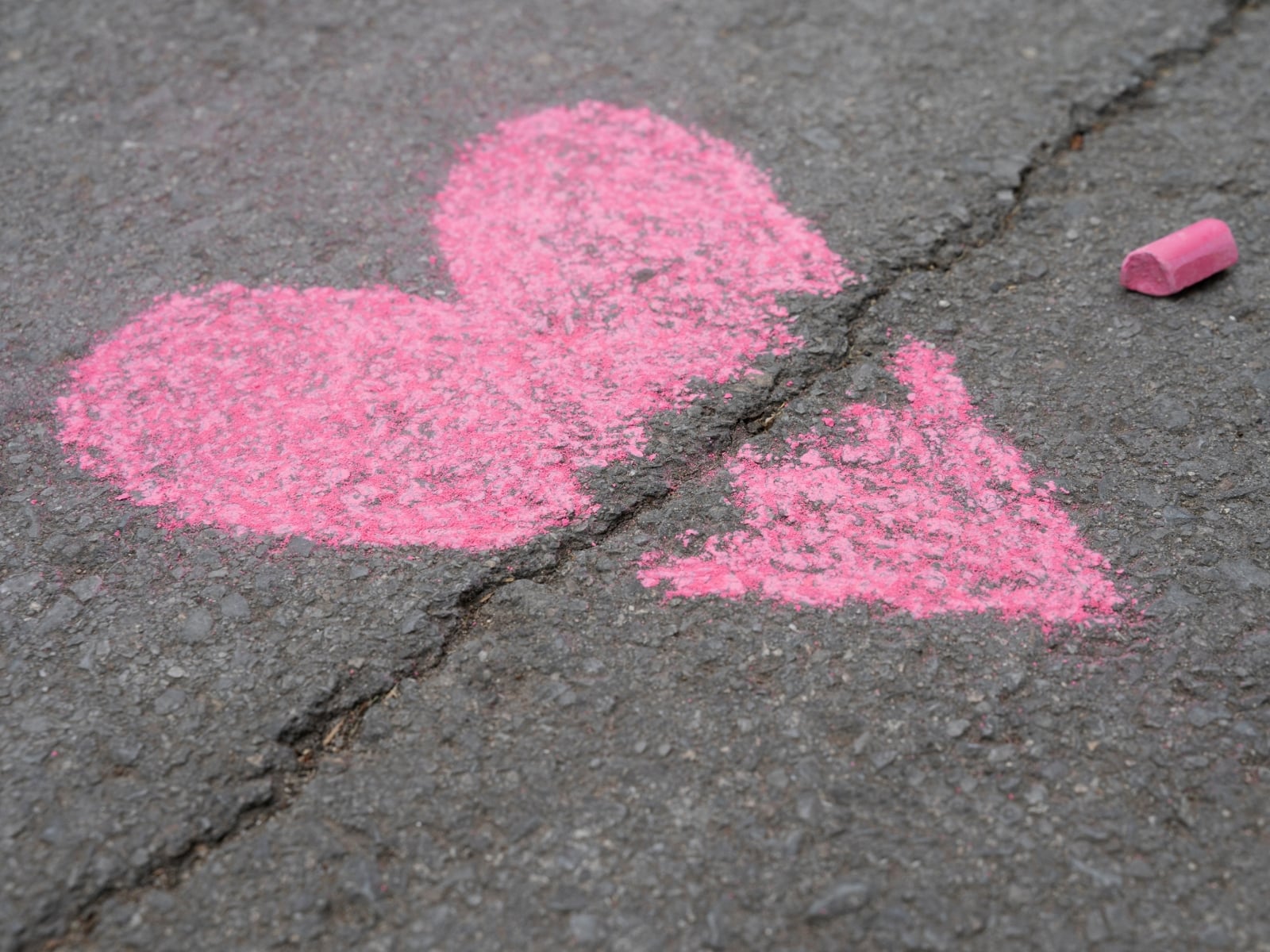 Imagen de un corazón roto en el asfalto.