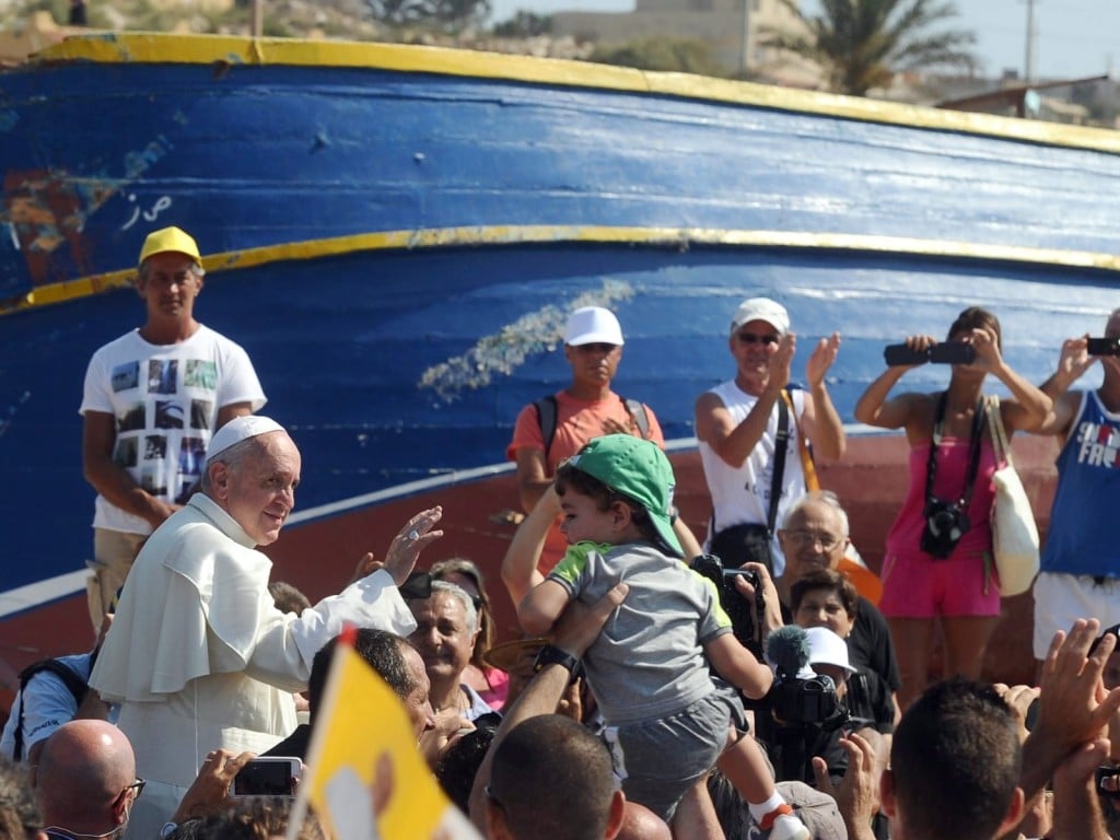 El papa Francisco (izq.) bendice a los fieles durante su visita a la isla de Lampedusa, sur de Italia, el 8 de julio de 2013. El papa Francisco llega a la isla de Lampedusa para orar por los migrantes y depositar una corona de flores en el mar por los cientos de personas que han muerto intentando llegar a Europa