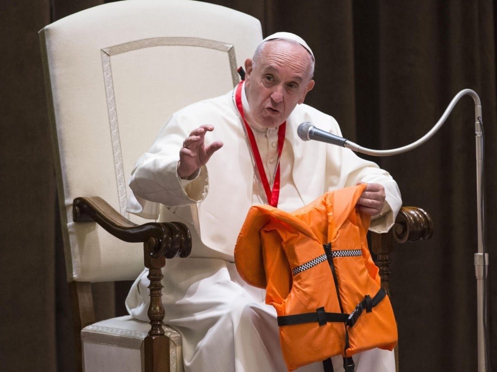 El papa Francisco muestra el chaleco salvavidas que le regaló un grupo de migrantes durante un encuentro con unos 400 niños procedentes de Calabria, el 28 de mayo de 2016, en el Vaticano.