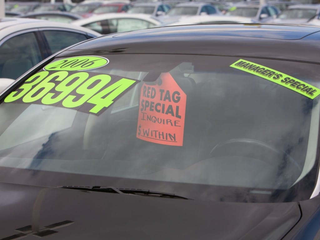 Foto de un auto usado en venta con el precio en el parabrisas